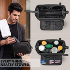 Necessaire em pele preta com abertura ampla, divisórias internas, elásticos para escovas e bolso com fecho; homem guarda tubo